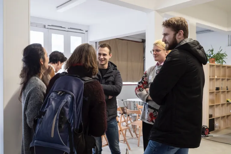 Students gather at the fore of the image, three to the left and one to the right